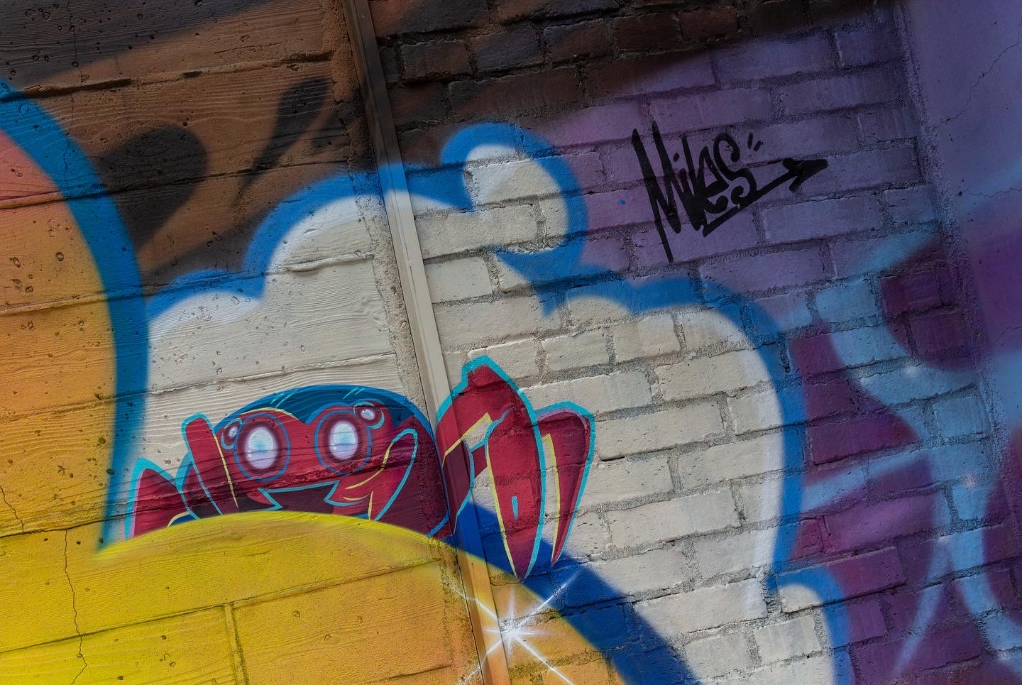 Section of brightly-colored street art with a stylized Spider-Bot