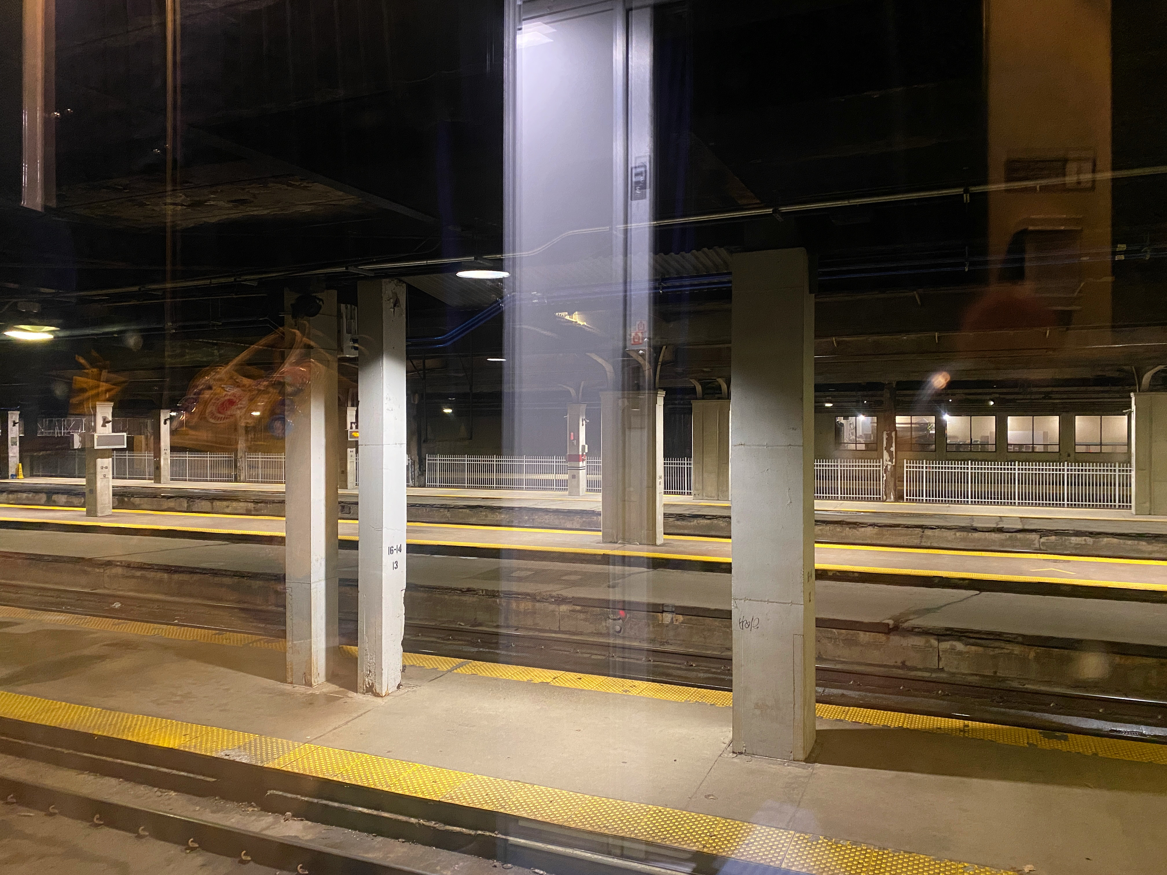 Ghostly image of the empty train station and the reflection of the inside of the train car in the window